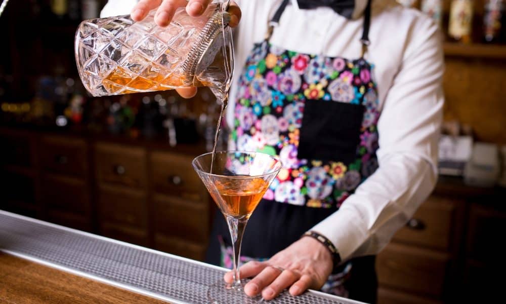 Un barman préparant un cocktail manhattan