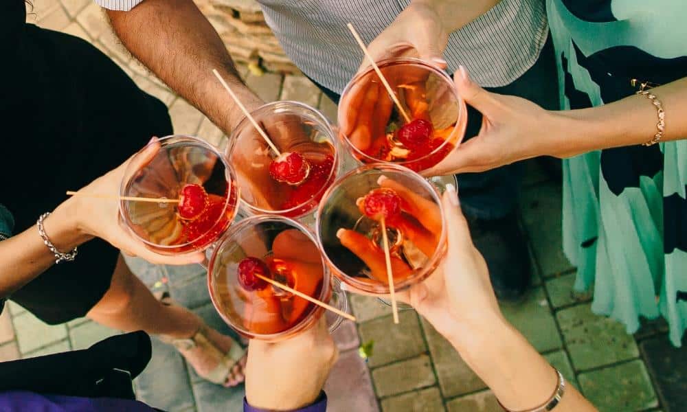 Des personnes trinquant avec du cocktail champagne