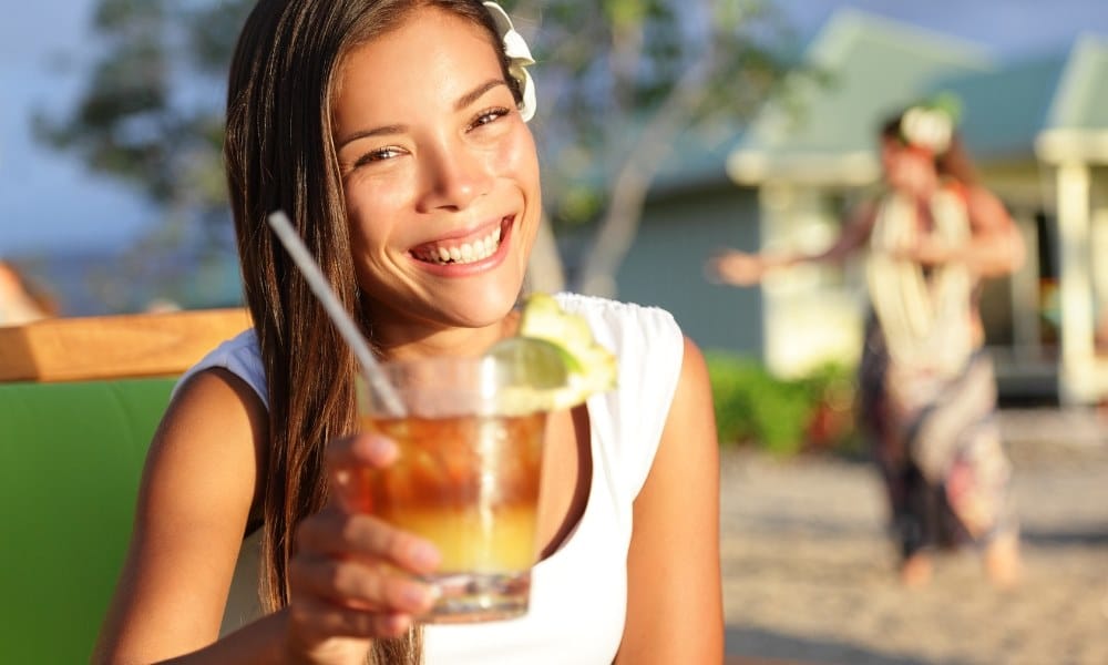 Une femme tenant un cocktail Mai Tai