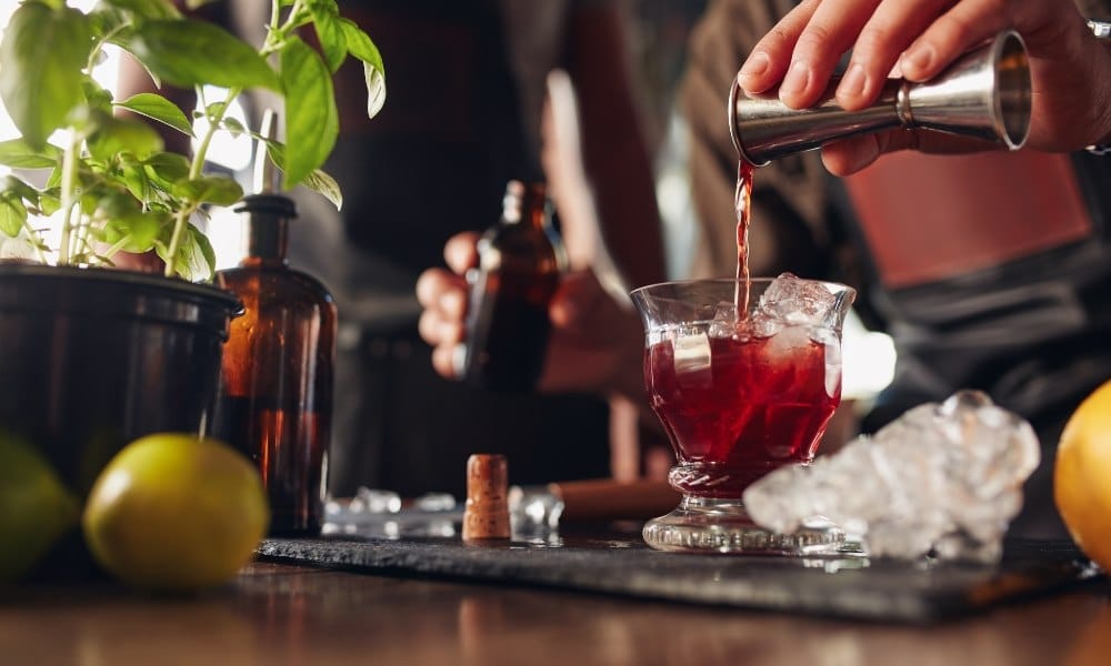 Un barman employant un doseur pour cocktail