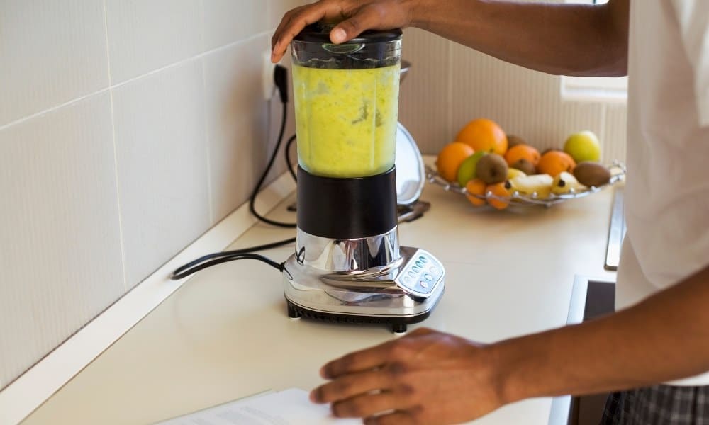 Un homme utilisant un blender pour cocktail