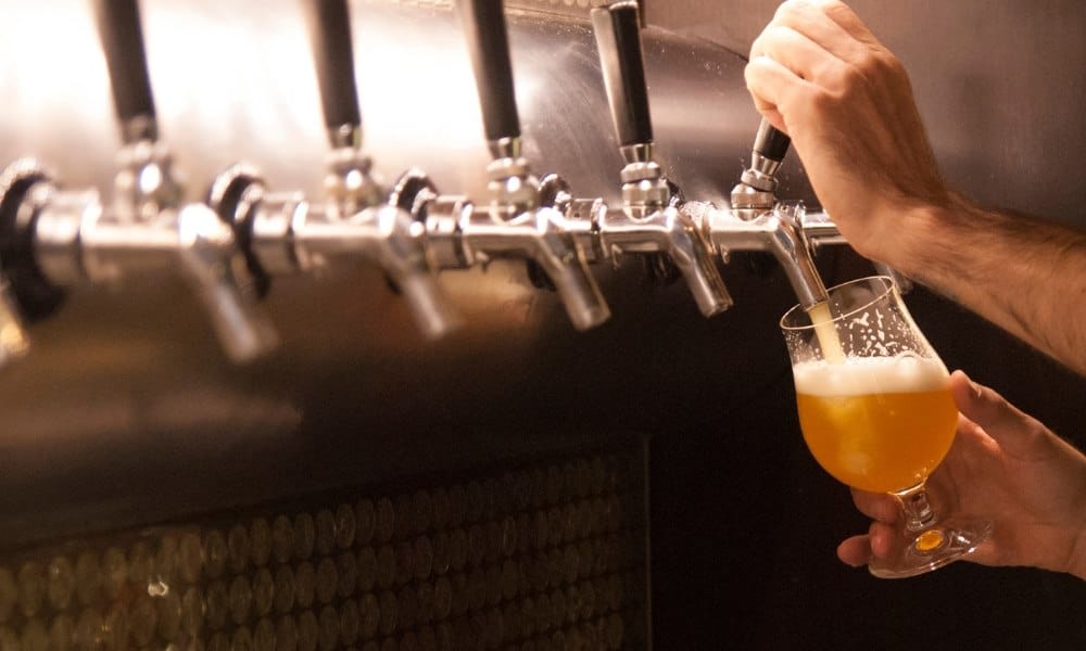 Quelqu'un versant de la bière à partir d'une tireuse à bière