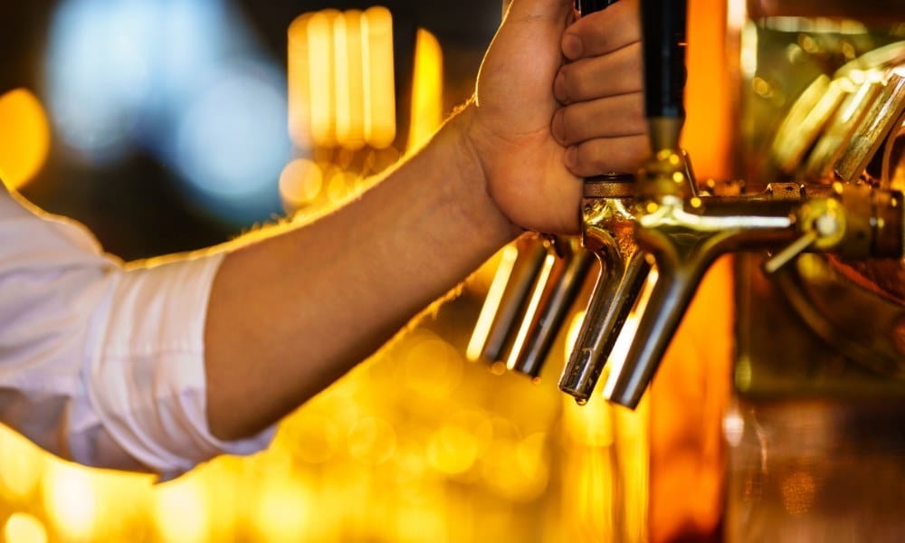 Quelqu'un versant de la bière à partir d'une tireuse à bière