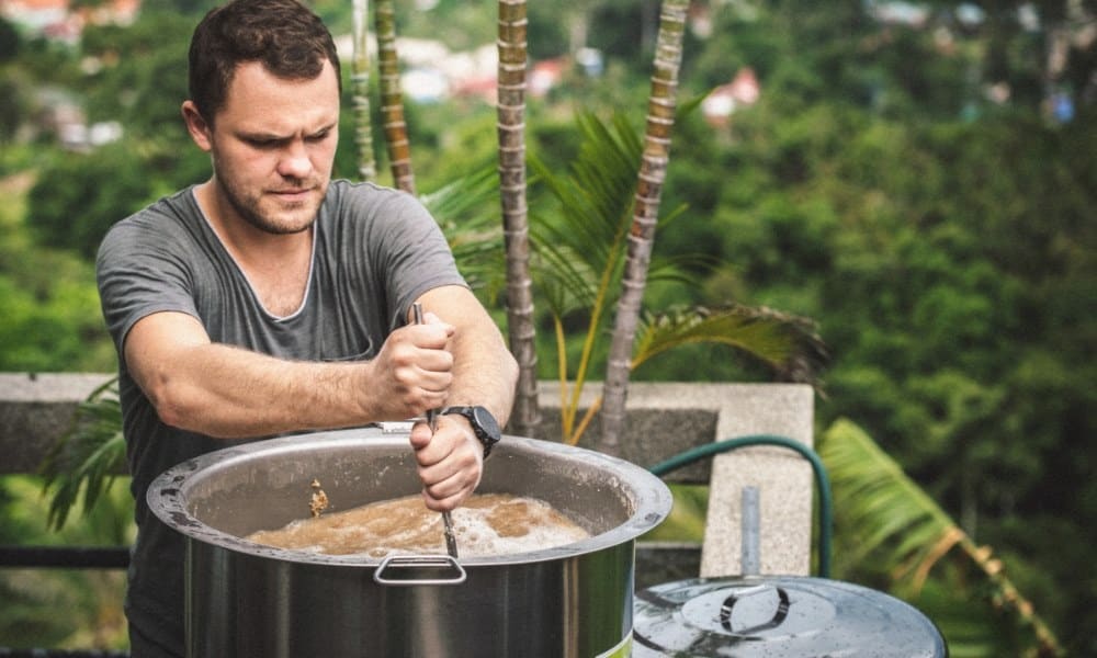 Un homme fabrique de la bière en employant le kit de bière Brew monkey
