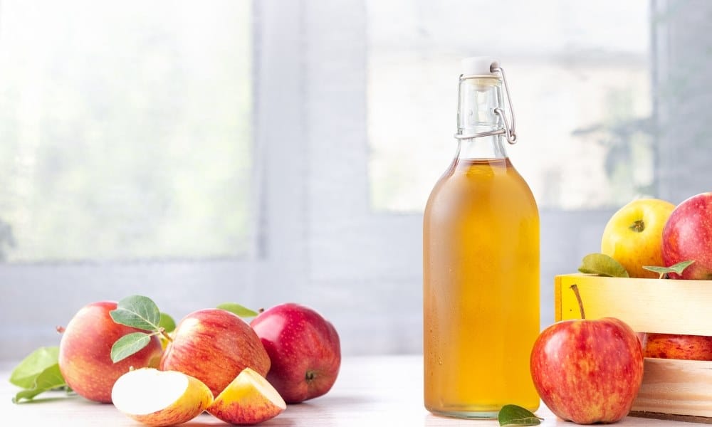 Bouteille remplie de cidre avec des pommes